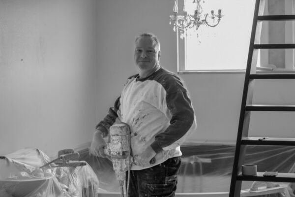 Stucadoor is met een mixer gips aan het mengen